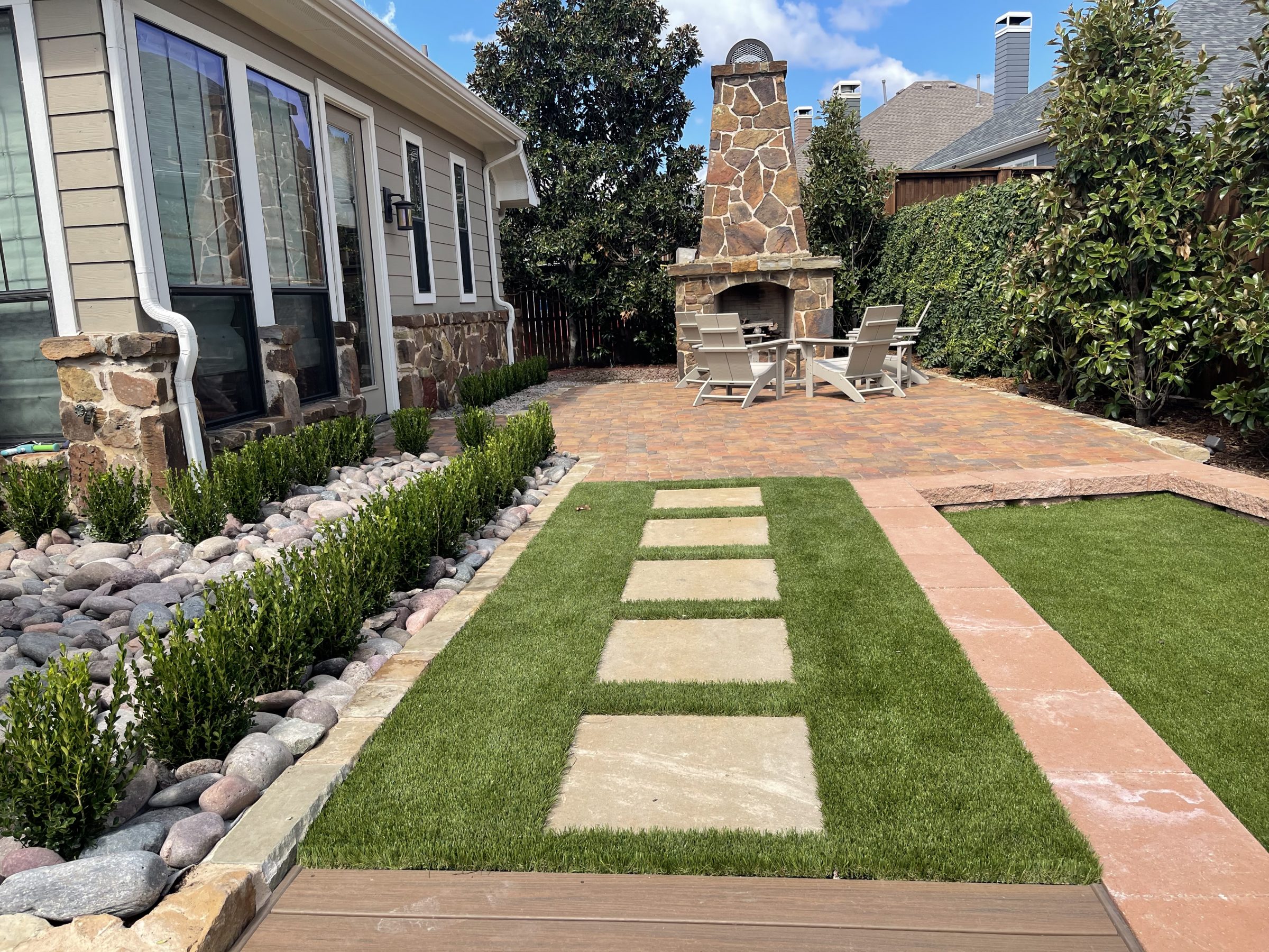 Backyard patio with stone fireplace and seating area