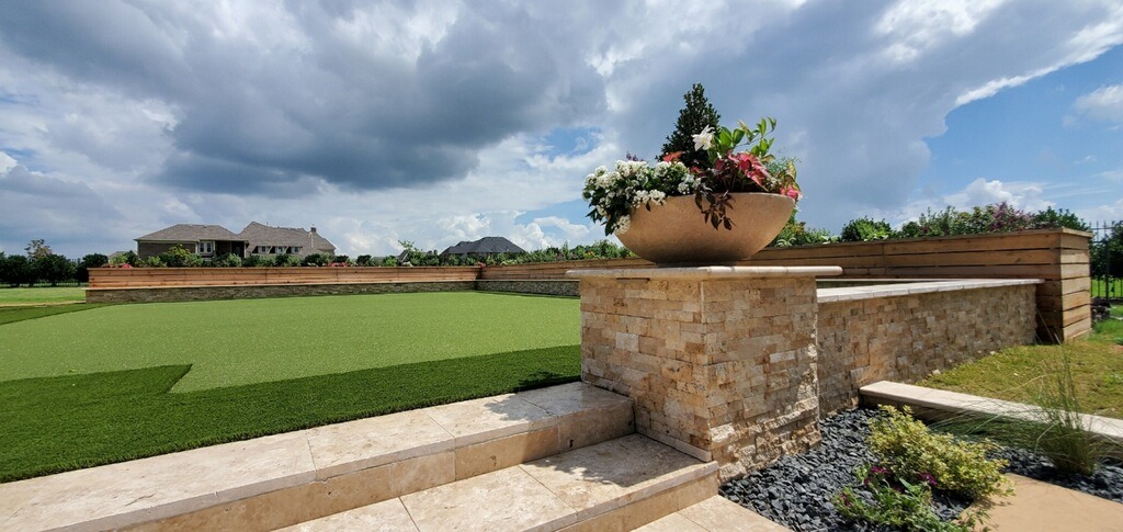 Beautiful landscaped garden with stone wall and flowers.