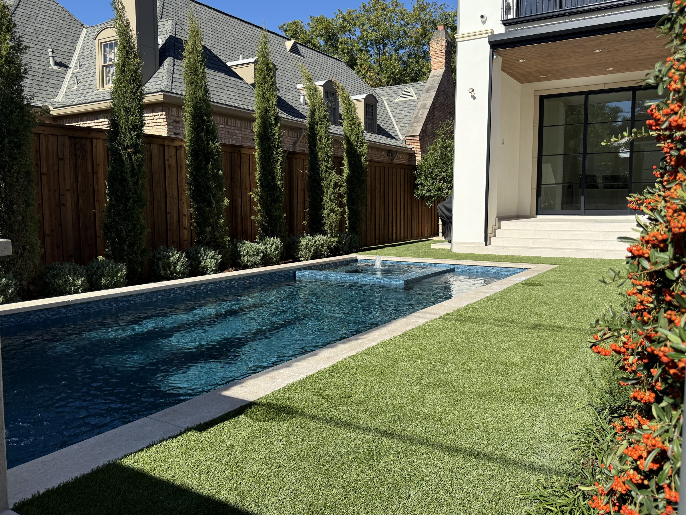 Modern backyard with pool and greenery.