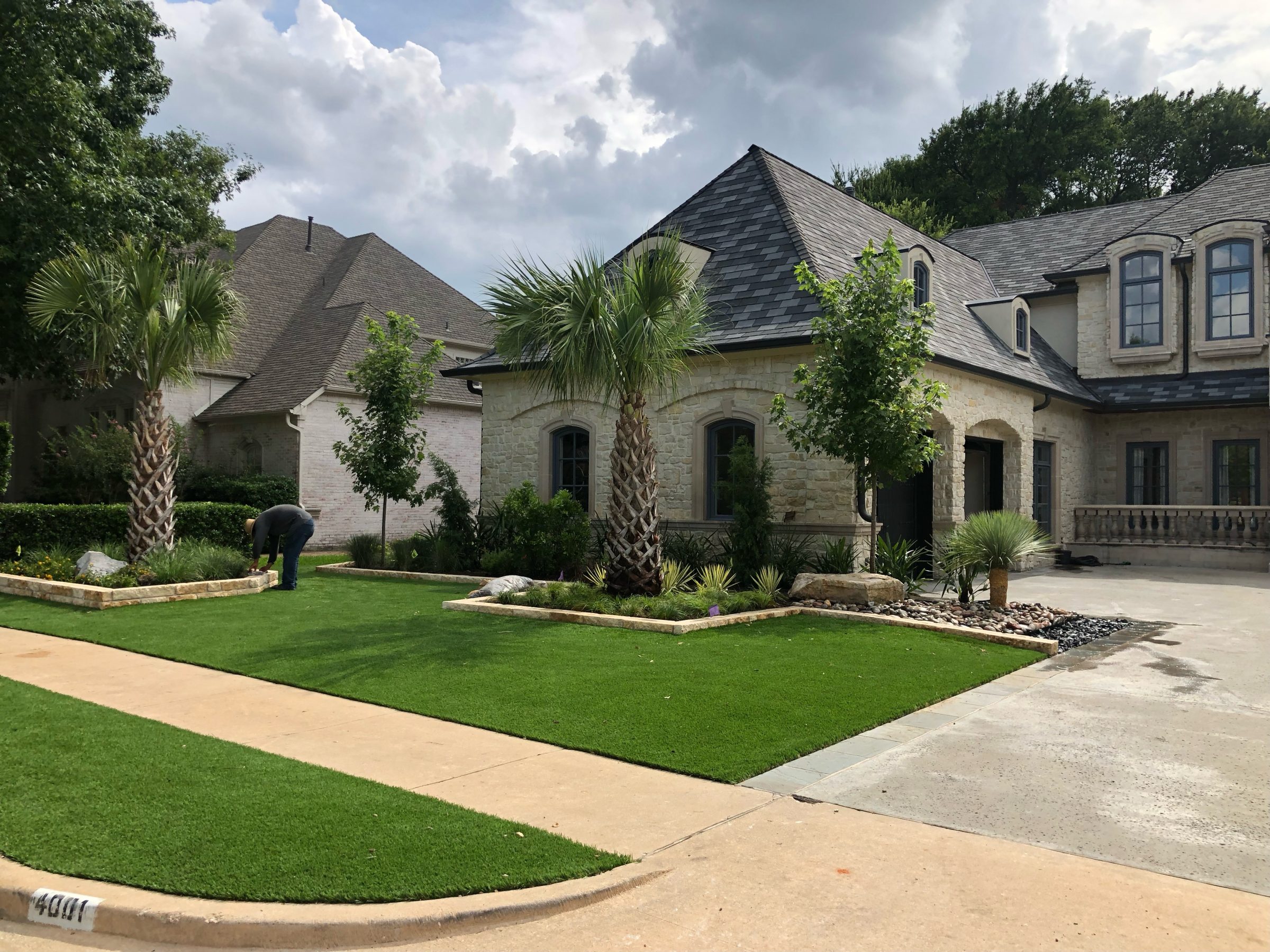 Elegant house with manicured lawn and palm trees.