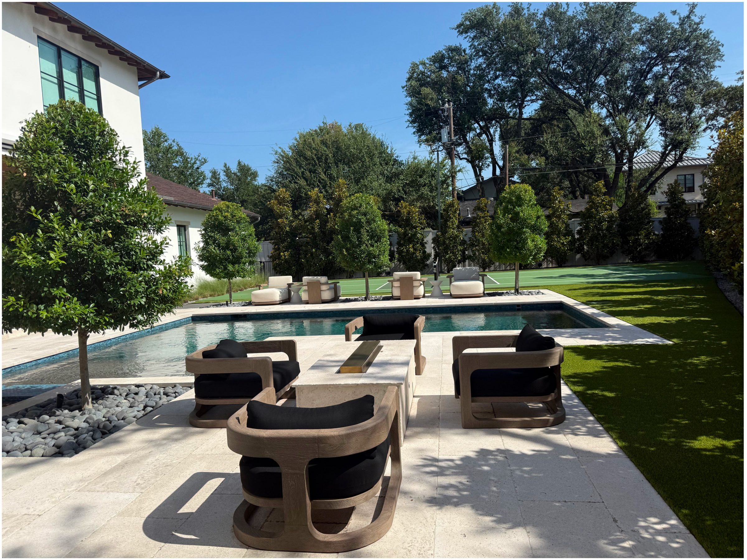 Modern patio with pool and seating area.