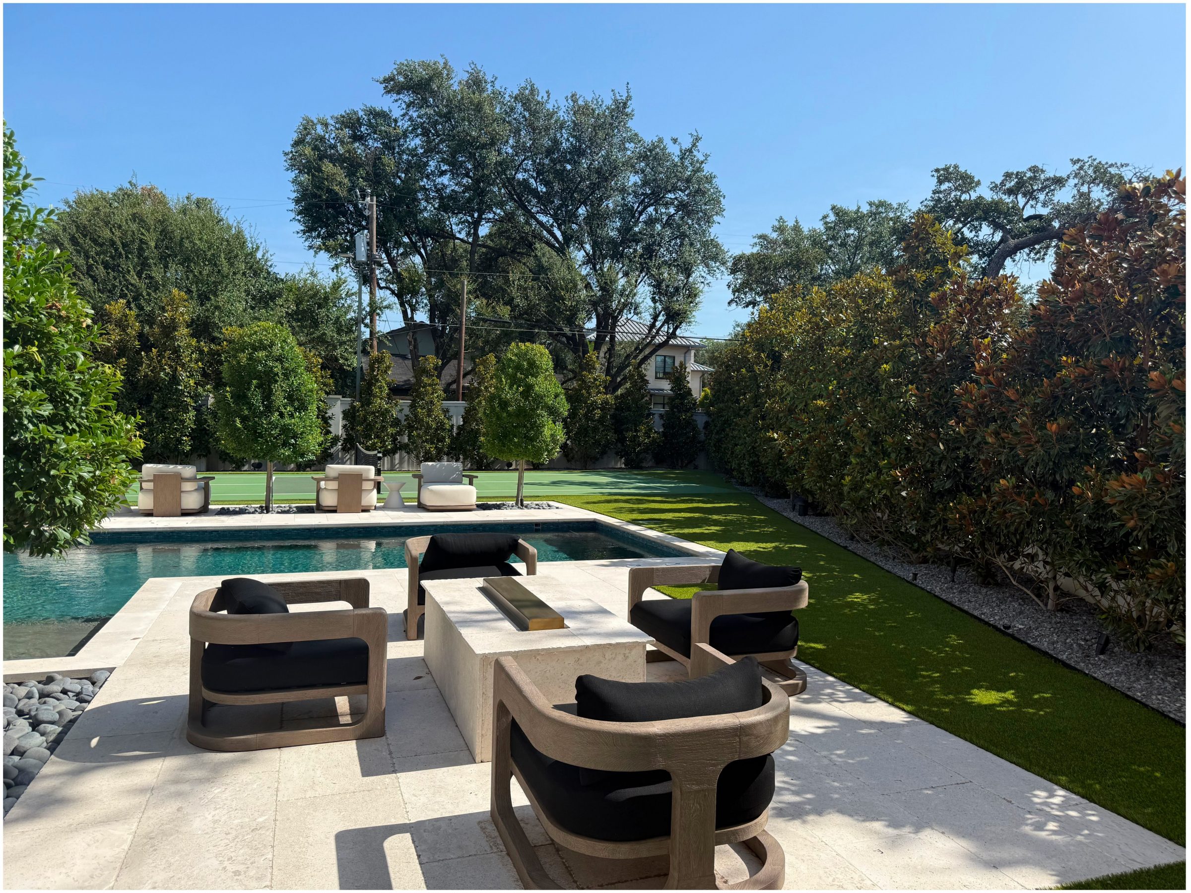 Modern patio with pool and greenery view.