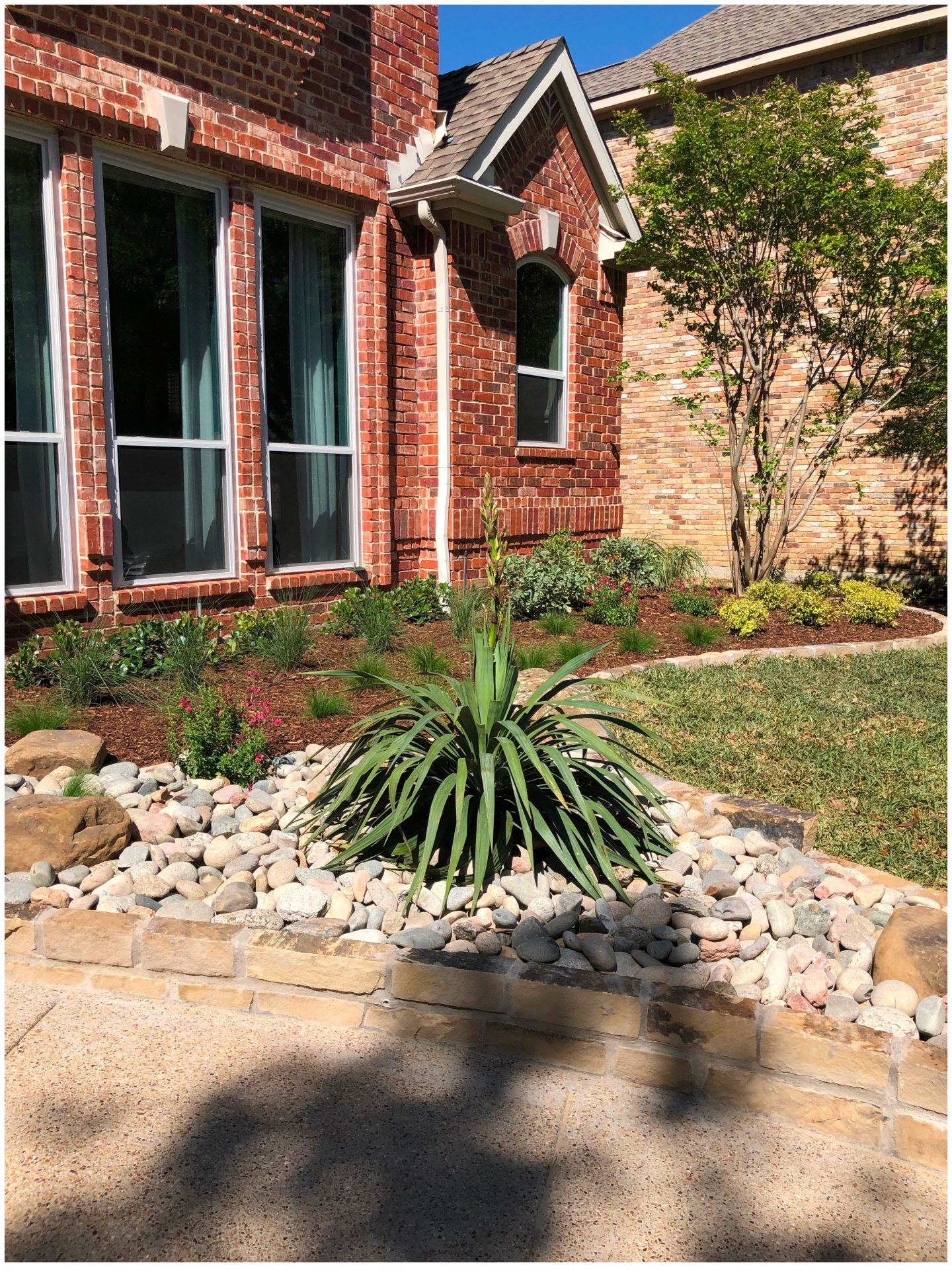 Brick house with landscaped garden and stone path.