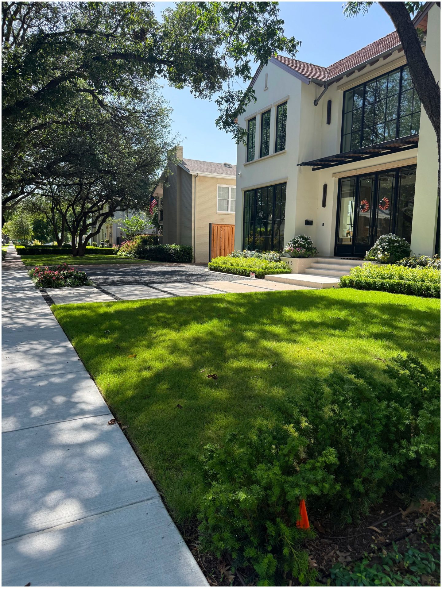 Modern house with manicured lawn and trees.