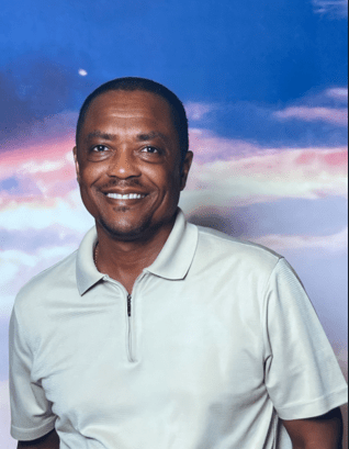 Smiling man in front of colorful sky background